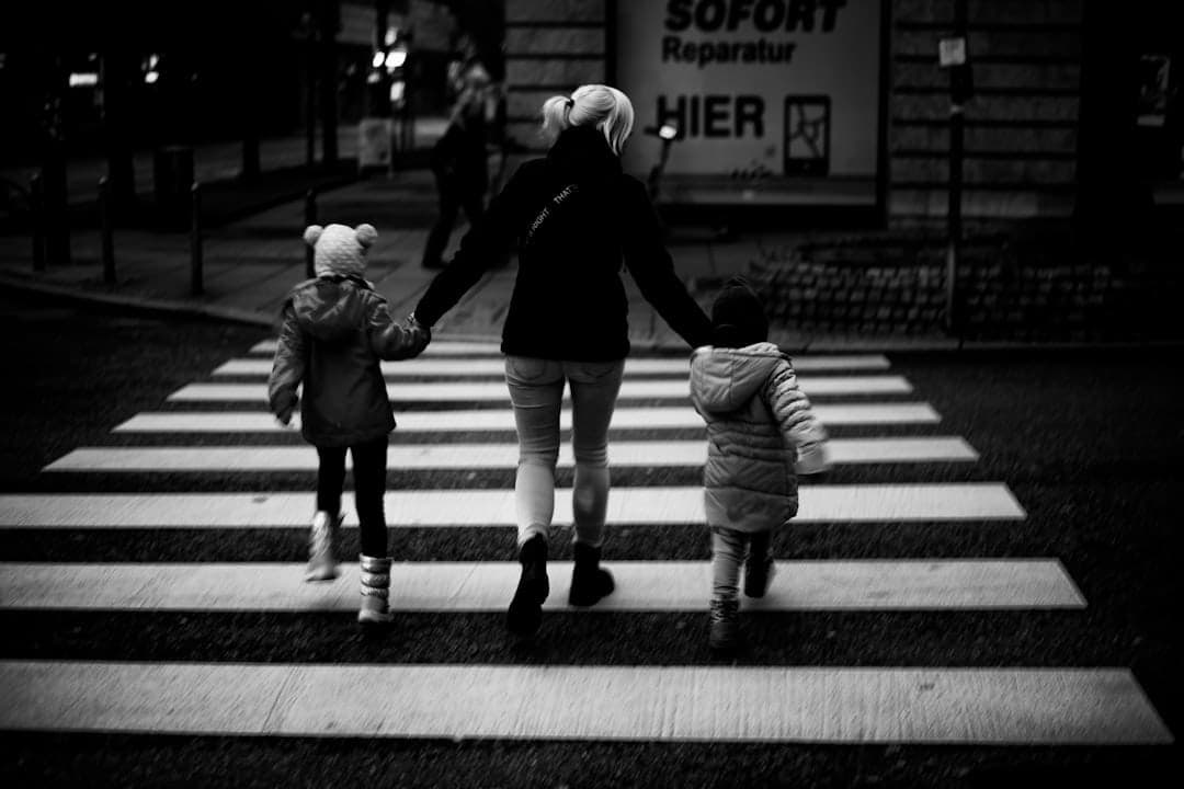 A woman and two children walking across a cross walk